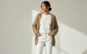 Relaxed weekend outfit: woman in a cozy taupe cardigan and white straight-leg jeans.