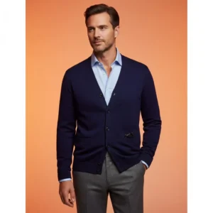 Academic chic: Man in a navy blue cardigan and grey wool trousers with a warm orange studio glow.