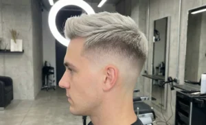 Profile view of a man receiving a straight razor shave on his neck from a barber in a vintage-style barbershop.