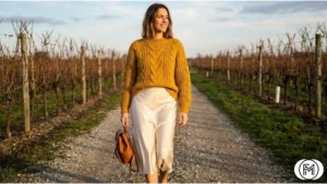 Casual winter vineyard outfit featuring a mustard yellow cable-knit sweater and cream satin skirt.