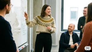 Dark denim jeans styled with a structured black blazer and leather Chelsea boots for smart casual work.
