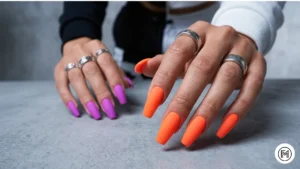 Alt Text: Trendy matte finish neon acrylic nails in electric orange and purple.