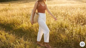 14 Linen Pants & Tank Top Breathable spring outfit featuring high-waisted white linen pants and a terracotta tank top with a straw bag.