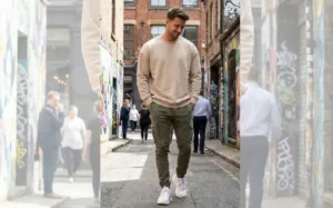 Man walking in a city alley wearing an oversized sweatshirt and olive cargo pants for street casual style.
