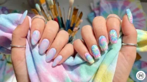 17. Tie-Dye Pastel: "Nostalgic 60s inspired pastel tie-dye nail design with soft pink and blue swirls."