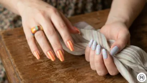 2. Retro Striped Nails: "70s style retro striped nail design with bold coral, yellow, and pastel lilac vertical lines."