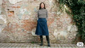 Dark wash denim midi skirt styled with a striped turtleneck and black knee-high leather boots.