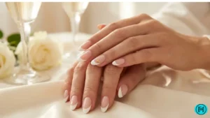 Elegant French tip nails with rhinestone accents on one accent nail.