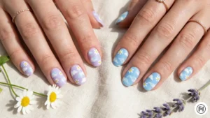 23. Cloudy Sky & Daisy: "Whimsical cloudy sky nail art with soft blue background and tiny white daisy accents."