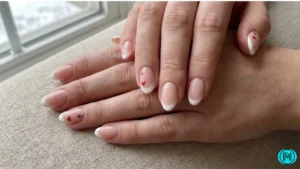 French tip nails featuring tiny Valentine symbols like hearts and arrows.