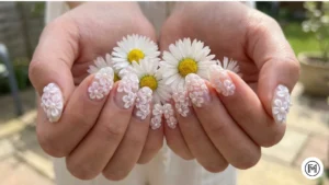 Alt Text: Artistic 3D flower acrylic nail art with textured white petals and pearl centers.