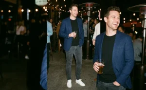 Man wearing a navy blazer over a t-shirt with slim jeans at an outdoor patio, illustrating a casual sharp outfit.