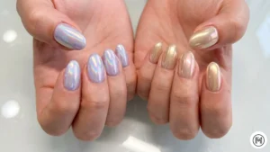 8. Iridescent Chrome: "Futuristic iridescent chrome nails in pastel lilac and pale blue with a mirrored glass finish."