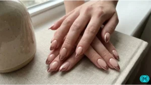 Nails with classic French tips and small red heart designs on accent nails.