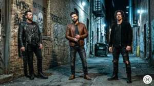 14. Edgy Classic

High-contrast shot of three men near a brick alleyway. They are wearing leather jackets (Biker, Café Racer, and Suede) with black jeans and combat/Chelsea boots. Cool, moody city lighting.

