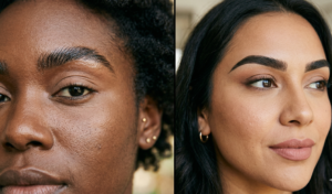 A landscape photograph of a dense redwood forest with incredibly tall trees, sunlight filtering down through the canopy to illuminate the misty air and the ferns on the forest floor.