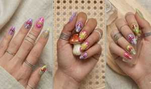 Whimsical nail art featuring hand-painted magic mushrooms and retro 1960s daisies in a bright purple, pink, and lime green color palette.