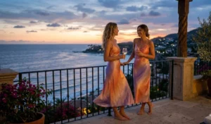"Two women wearing sunset-colored ombre silk slip dresses at dusk."