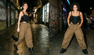 Two women blending edgy streetwear with evening glam in oversized olive-brown parachute pants paired with structured strappy corset tops.