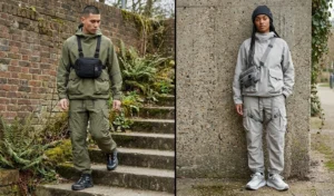 Two people modeling utilitarian Gorpcore streetwear with water-resistant relaxed hoodies, multi-pocketed olive and stone grey cargo pants, and rugged trail sneakers.